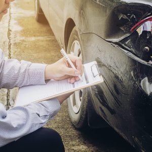 Insurance agent working on car accident claim process Insurance agent working on car accident claim process